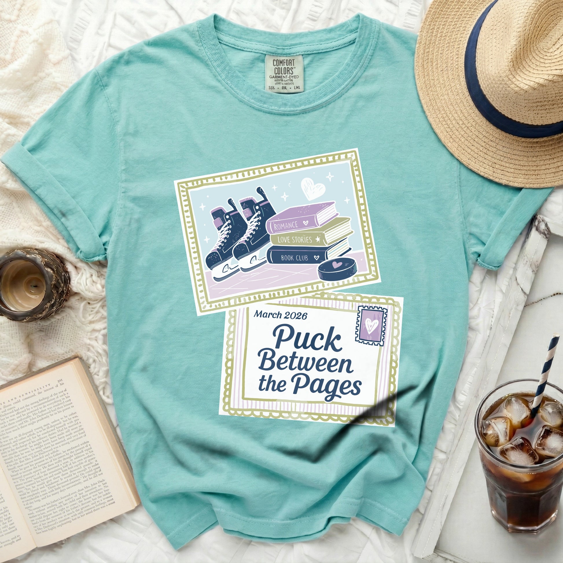 Teal t-shirt with "Puck Between the Pages" book and hockey graphic.