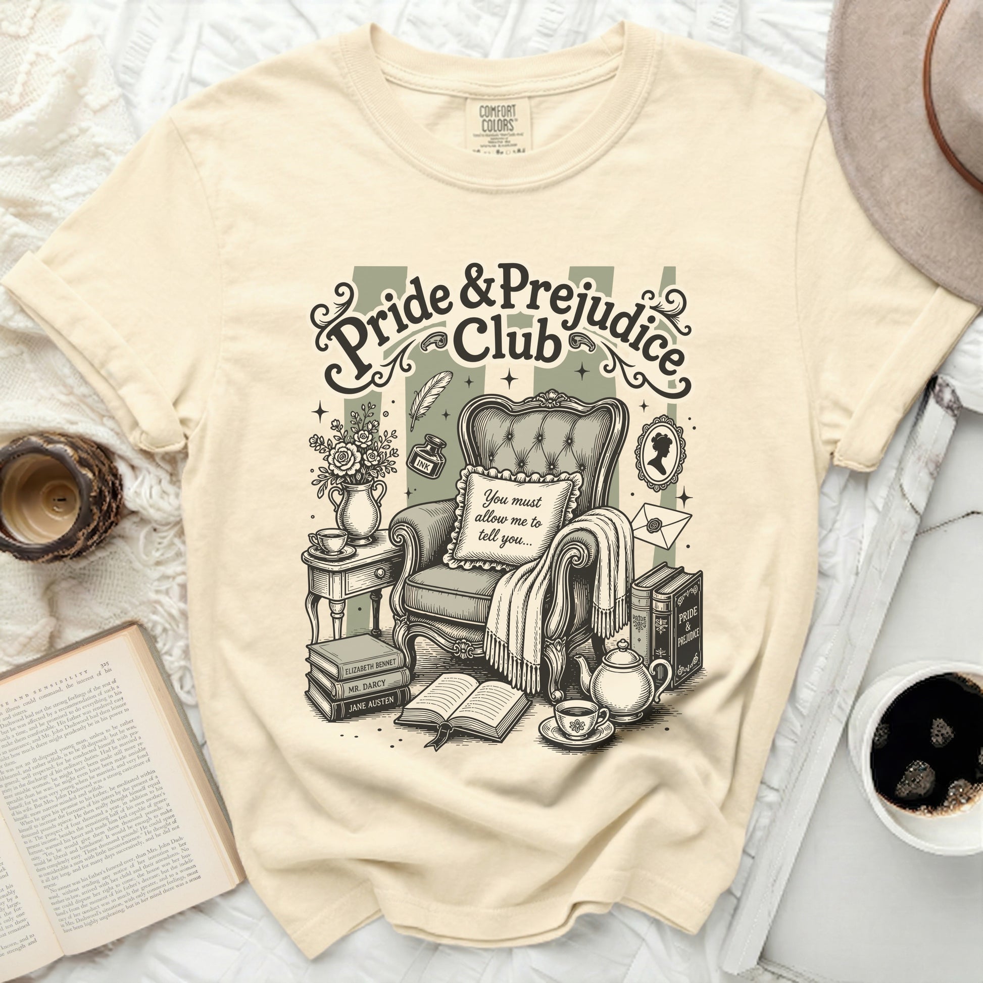 Pride & Prejudice Club graphic on beige t-shirt with armchair and books.