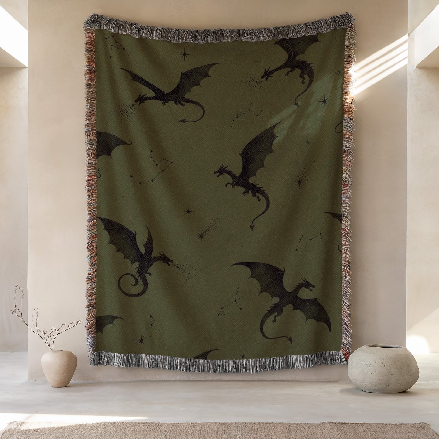 a large tapestry hanging on a wall, depicting a dragon design with stars and a crescent moon. The tapestry is green and has a fringe trim around the edges. There are two small vases placed on either side of the tapestry, and the background appears to be a white wall with a window.