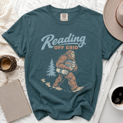Bigfoot carrying books and a rolled-up mat, text reads "Reading Off Grid".