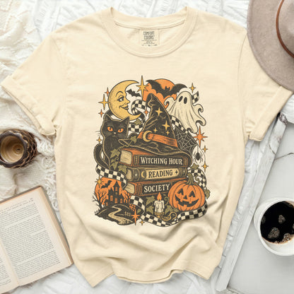 Cream t-shirt with vintage Halloween graphic of a cat, books, and witch hat.