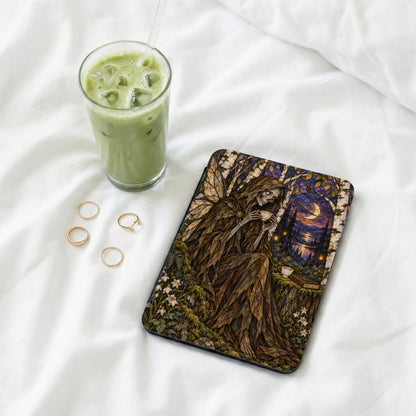 Eerie fairy illustration on a dark cover with a glass of matcha and gold rings.