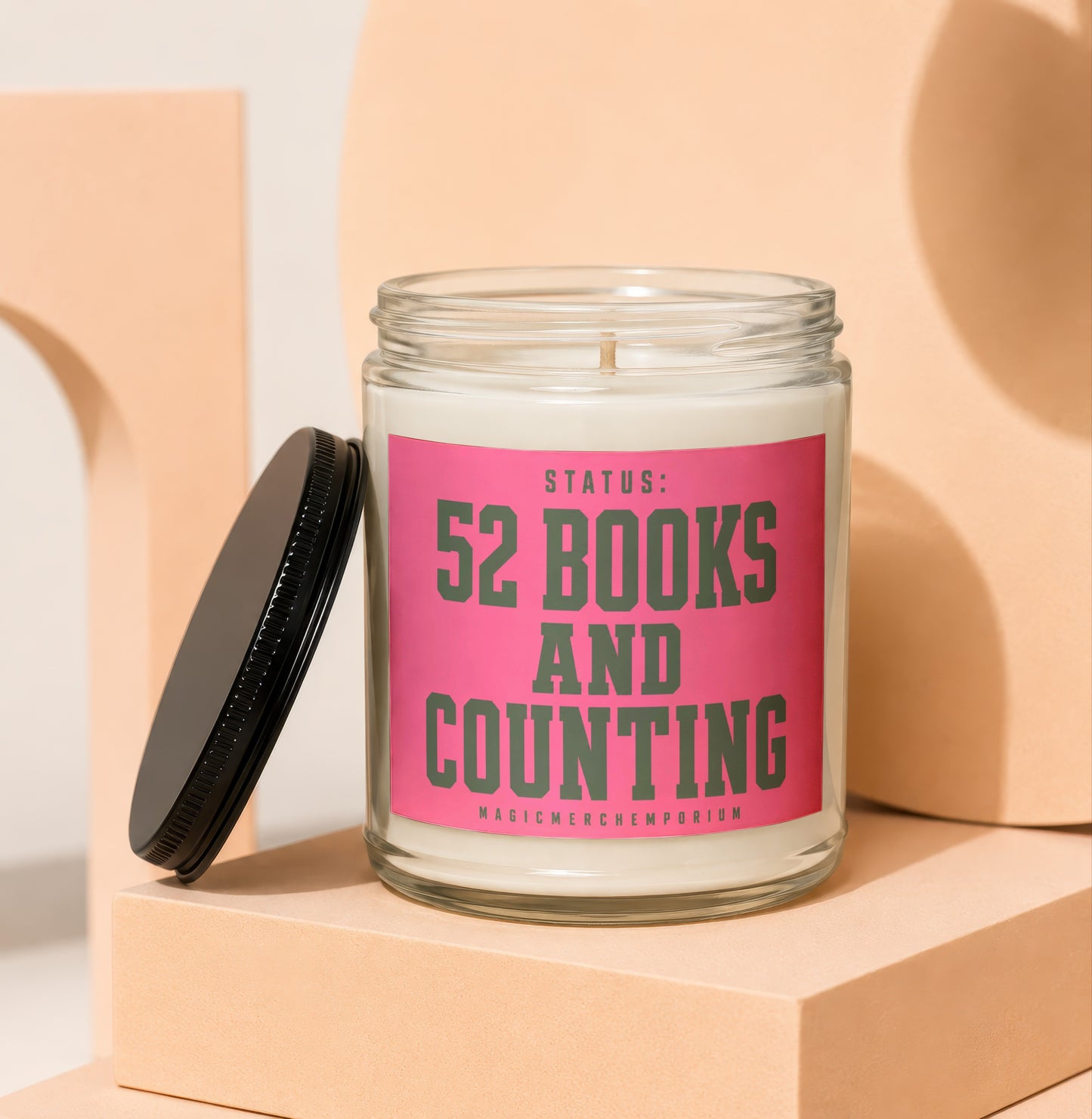 Glass candle with hot pink label reading "Status: 52 Books and Counting."