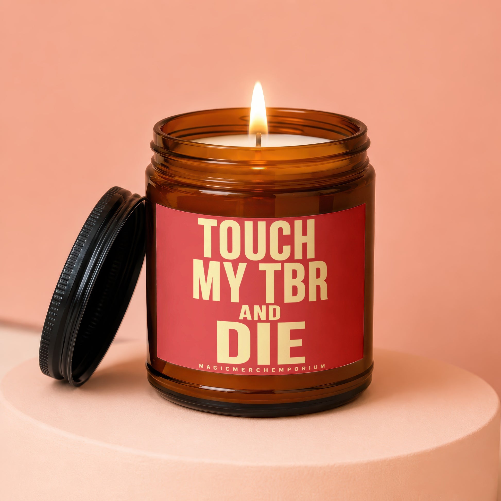 Amber jar candle with lit flame, black lid, and text "TOUCH MY TBR AND DIE"