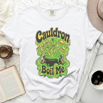 White t-shirt with "Cauldron Boil Me" graphic featuring a cauldron, skulls, and flowers.