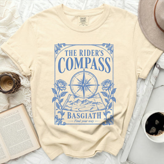 Cream t-shirt with blue "The Rider's Compass Basgiath Find your way" graphic.