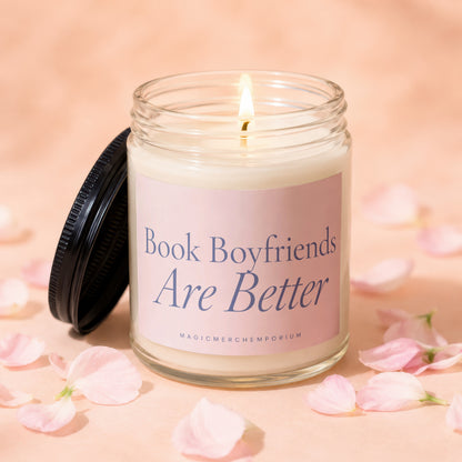 Candle with lid removed, lit wick, and text "Book Boyfriends Are Better" on a pink label.