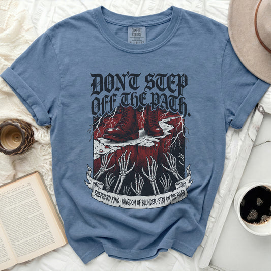 Blue t-shirt with graphic of boots, hands, and text "Don't Step Off The Path."