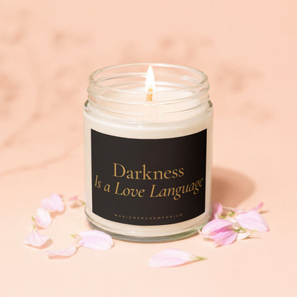 Lit candle in a glass jar with "Darkness Is a Love Language" text on label.
