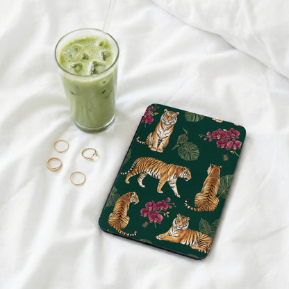 Dark green surface with a tiger and floral pattern, next to iced green drink and rings.