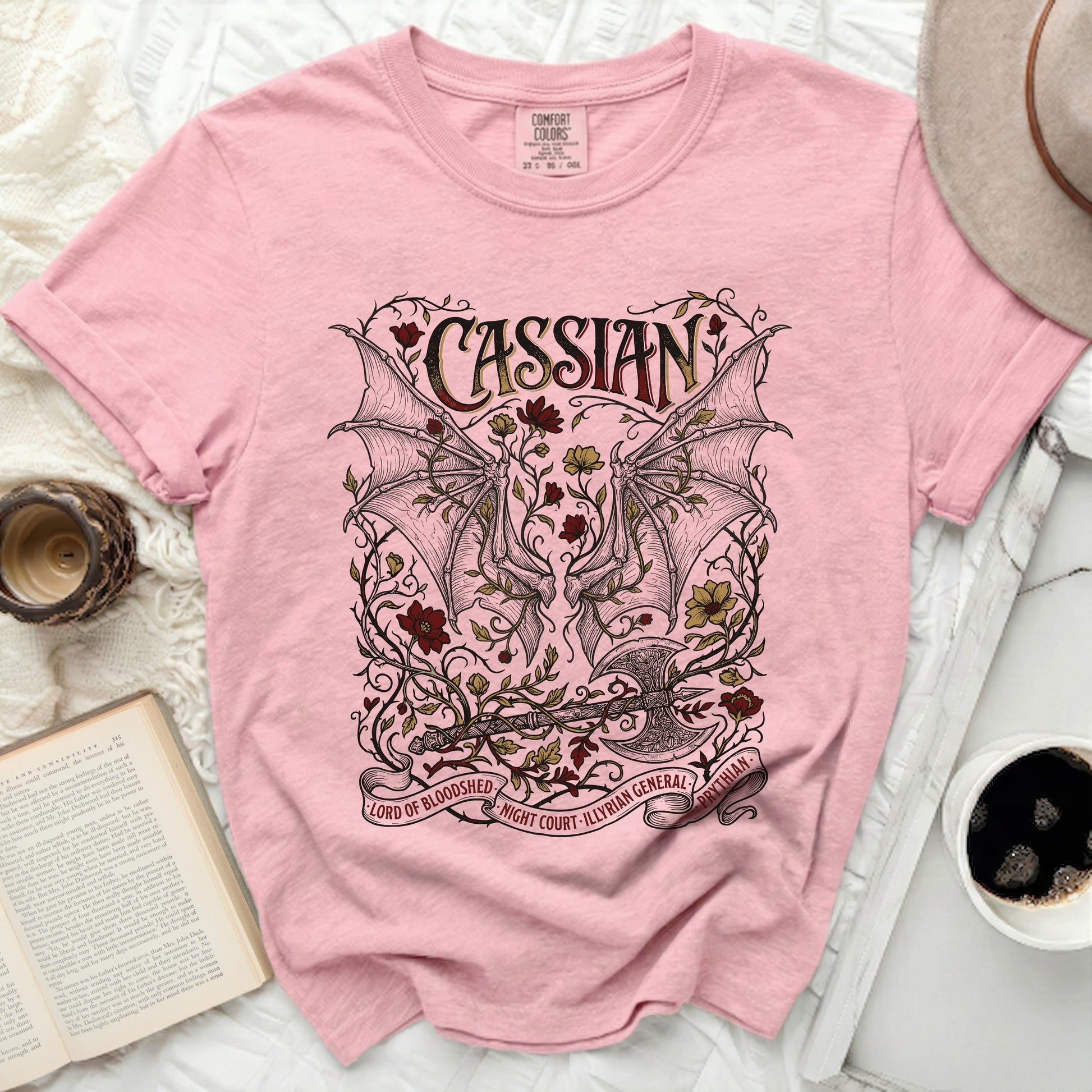 Pink t-shirt with Cassian, dragon wings, axe, and floral design.