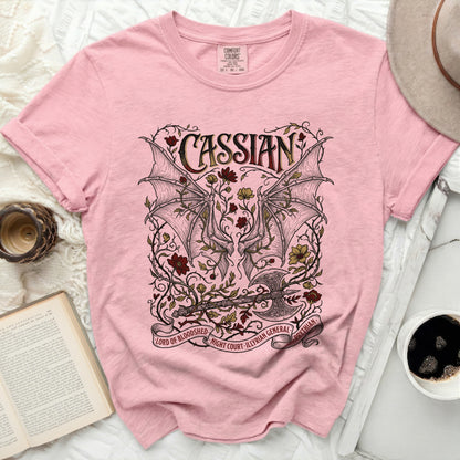 Pink t-shirt with Cassian, dragon wings, axe, and floral design.
