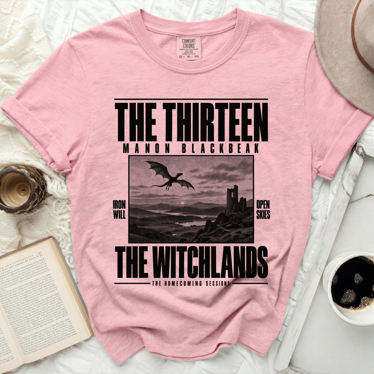 Pink t-shirt with "The Thirteen Manon Blackbeak The Witchlands" text and dragon image.