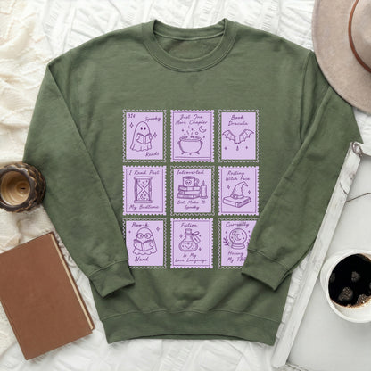Green sweatshirt with purple stamp-style graphics of ghosts, witches, and books.