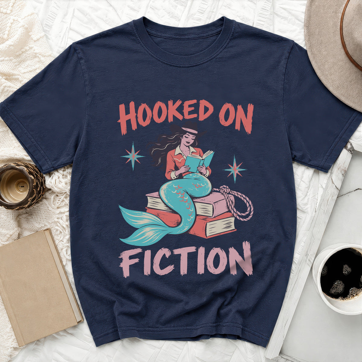 Navy t-shirt with "Hooked on Fiction" text and a mermaid reading on books.