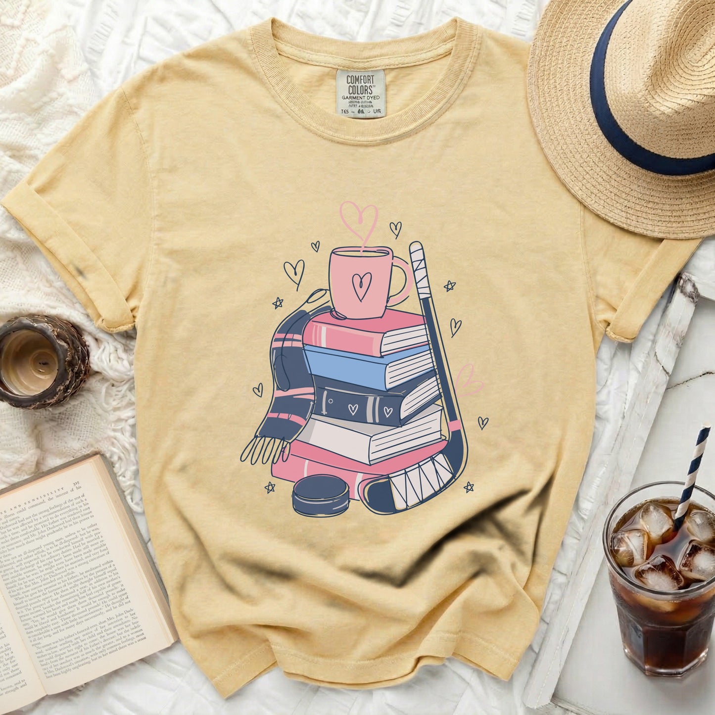 Yellow t-shirt with stack of books, hockey stick, puck, and heart graphic.