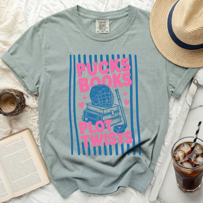 T-shirt with "Pucks, Books, Plot Twists" and hockey graphic on blue stripes.