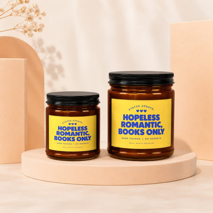 Two amber glass candles with yellow labels reading "Hopeless Romantic, Books Only".