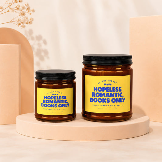 Two amber glass candles with yellow labels reading "Hopeless Romantic, Books Only".