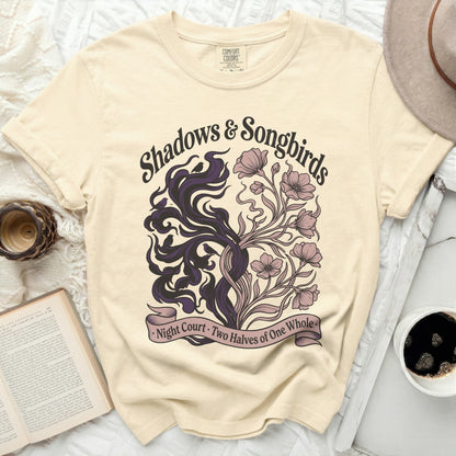 Cream t-shirt with "Shadows & Songbirds" text and floral/shadow design.