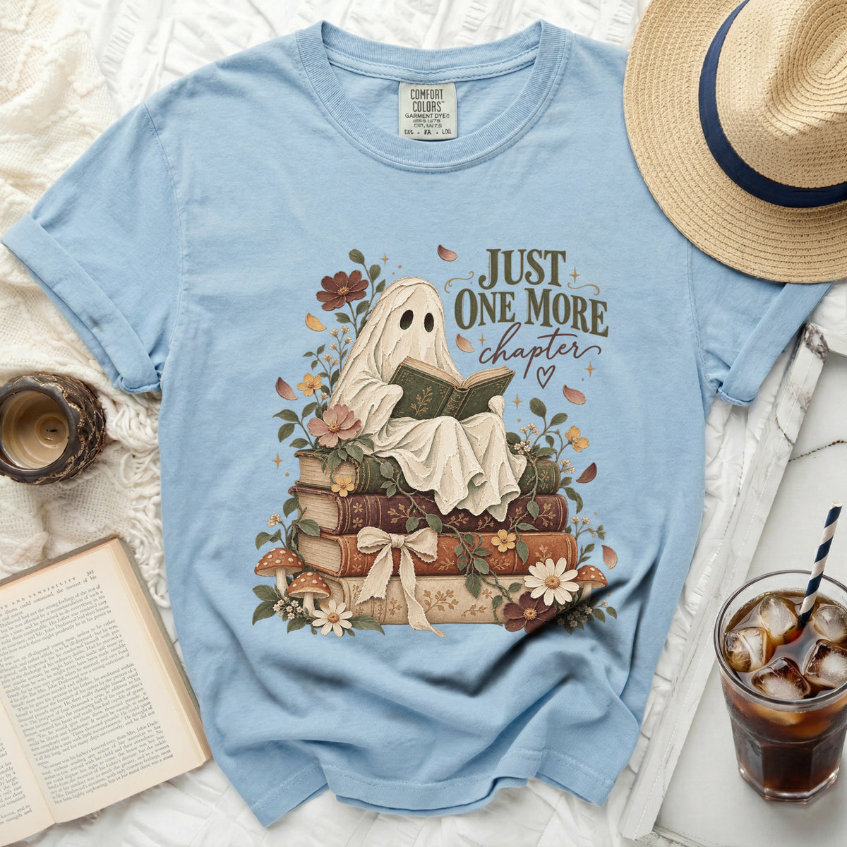 Ghost reading a book on a stack of books with floral accents and text "JUST ONE MORE chapter".