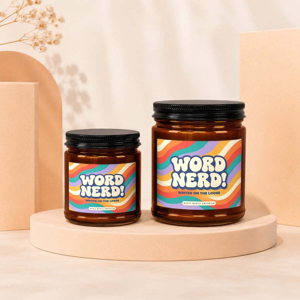 Two amber glass candles with colorful retro wave labels reading "WORD NERD! WRITER ON THE LOOSE".