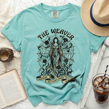 Teal t-shirt with "The Weaver" design of a woman surrounded by webs and skulls.
