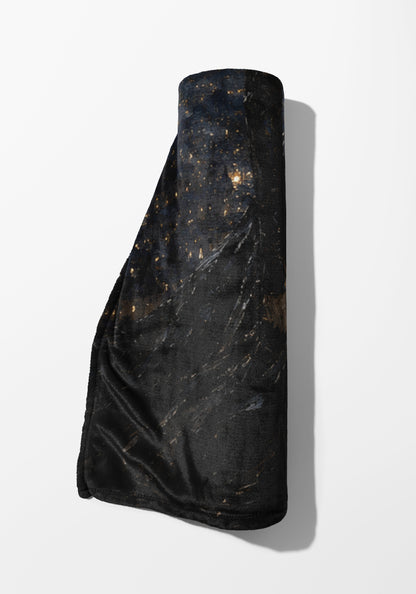 Rolled black throw blanket with a dark, speckled pattern resembling a starry night.
