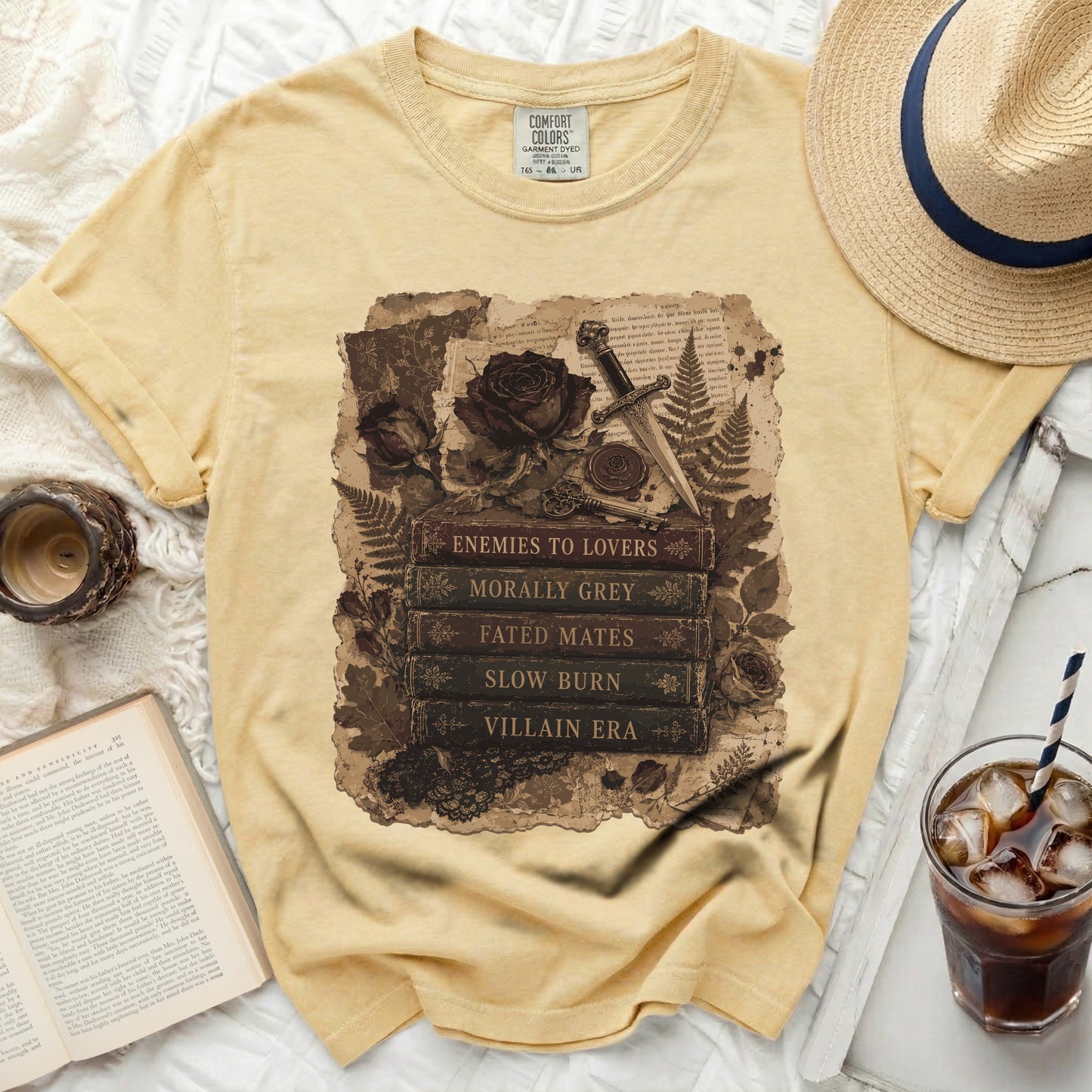 Yellow t-shirt with "Enemies to Lovers" book stack graphic.