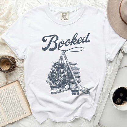 White t-shirt with "Booked" text above hockey skates, stick, and puck.