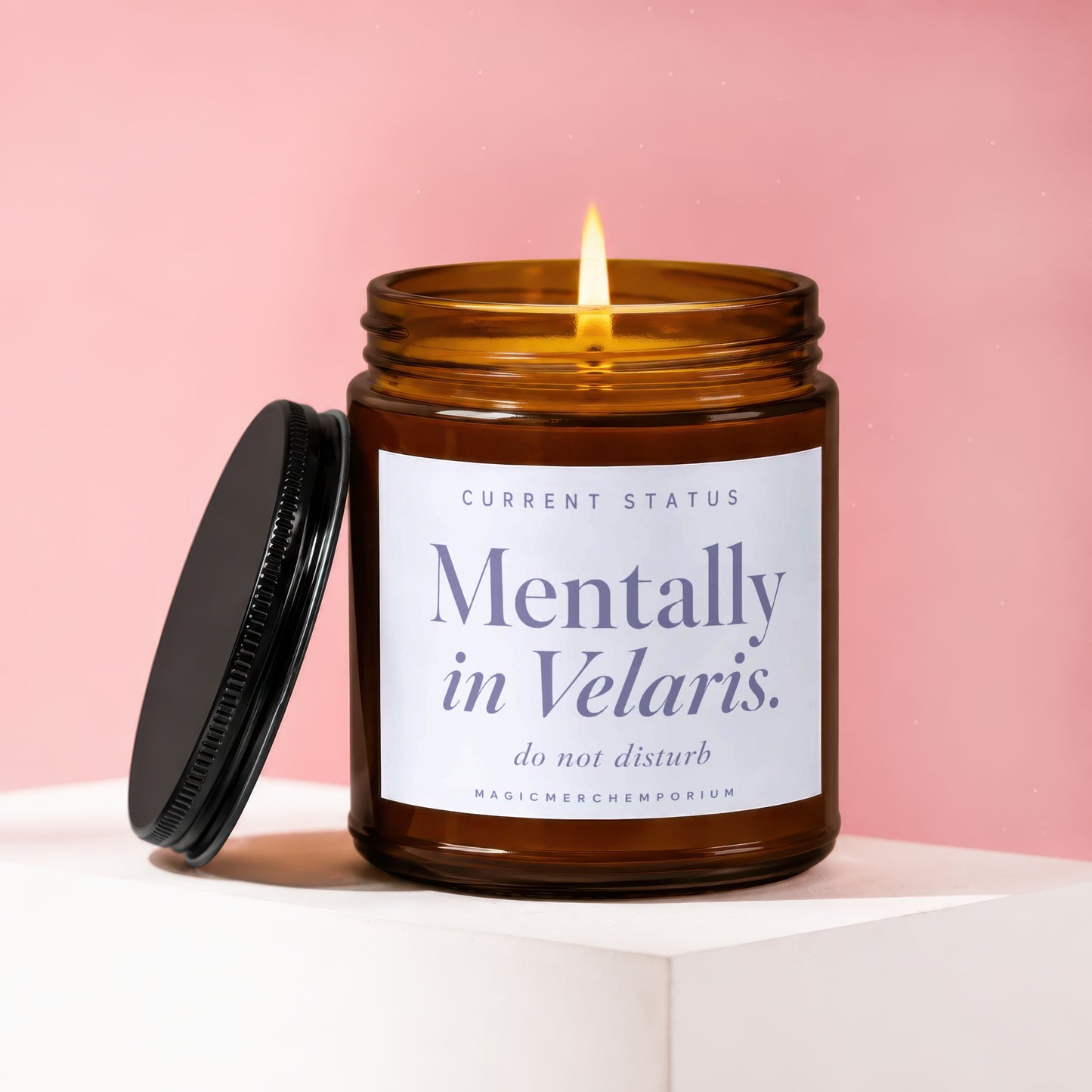 Amber candle with lit wick, lid removed, labeled "Mentally in Velaris. do not disturb."
