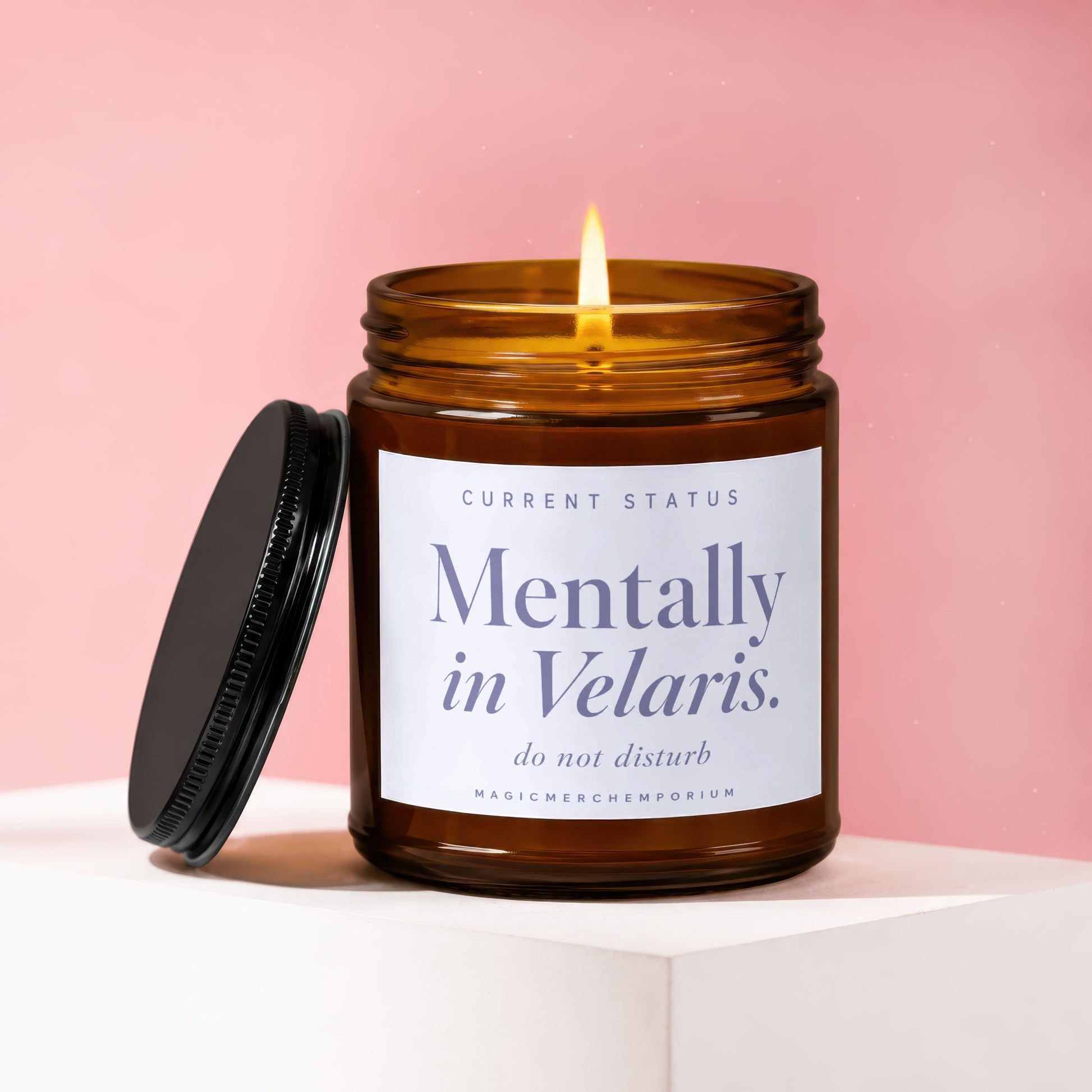 Amber candle with lit wick, lid removed, labeled "Mentally in Velaris. do not disturb."