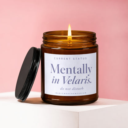 Amber candle with lit wick, lid removed, labeled "Mentally in Velaris. do not disturb."