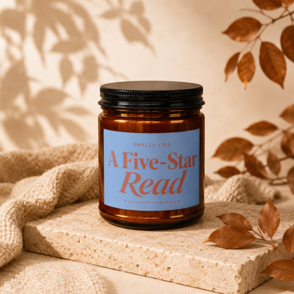 Amber candle with blue label reading "A Five-Star Read" on a stone block.