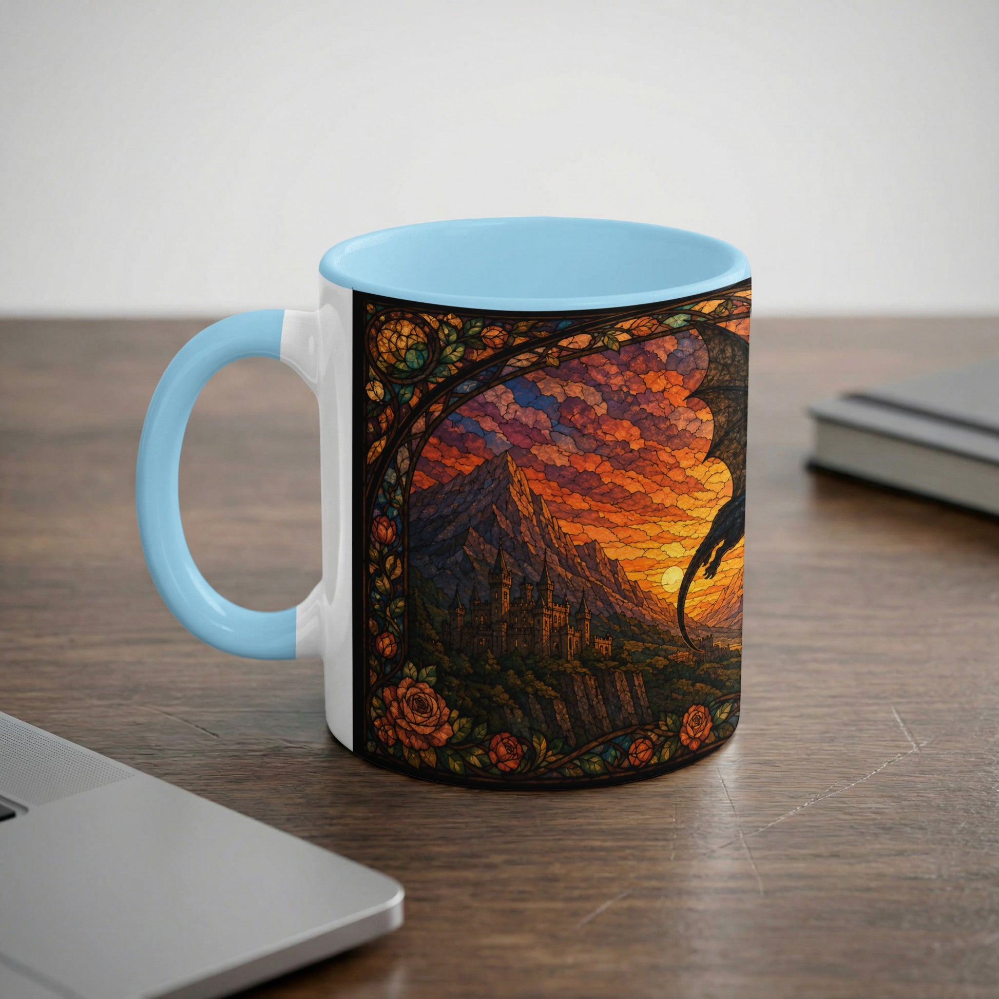 White mug with light blue handle featuring stained glass art of a dragon over a castle at sunset.