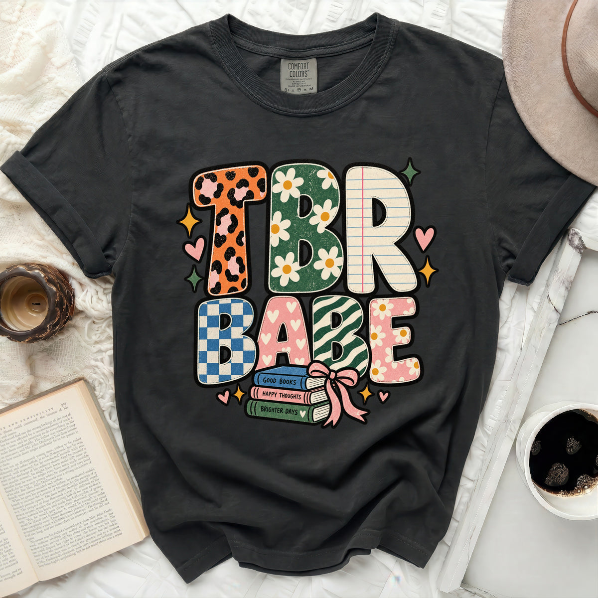 TBR Babe graphic tee with books, hearts, and floral designs.