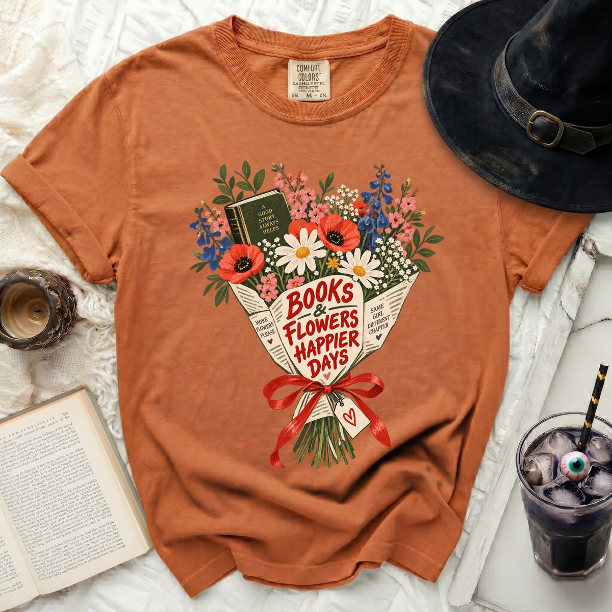 Orange t-shirt with "Books & Flowers Happier Days" floral graphic.