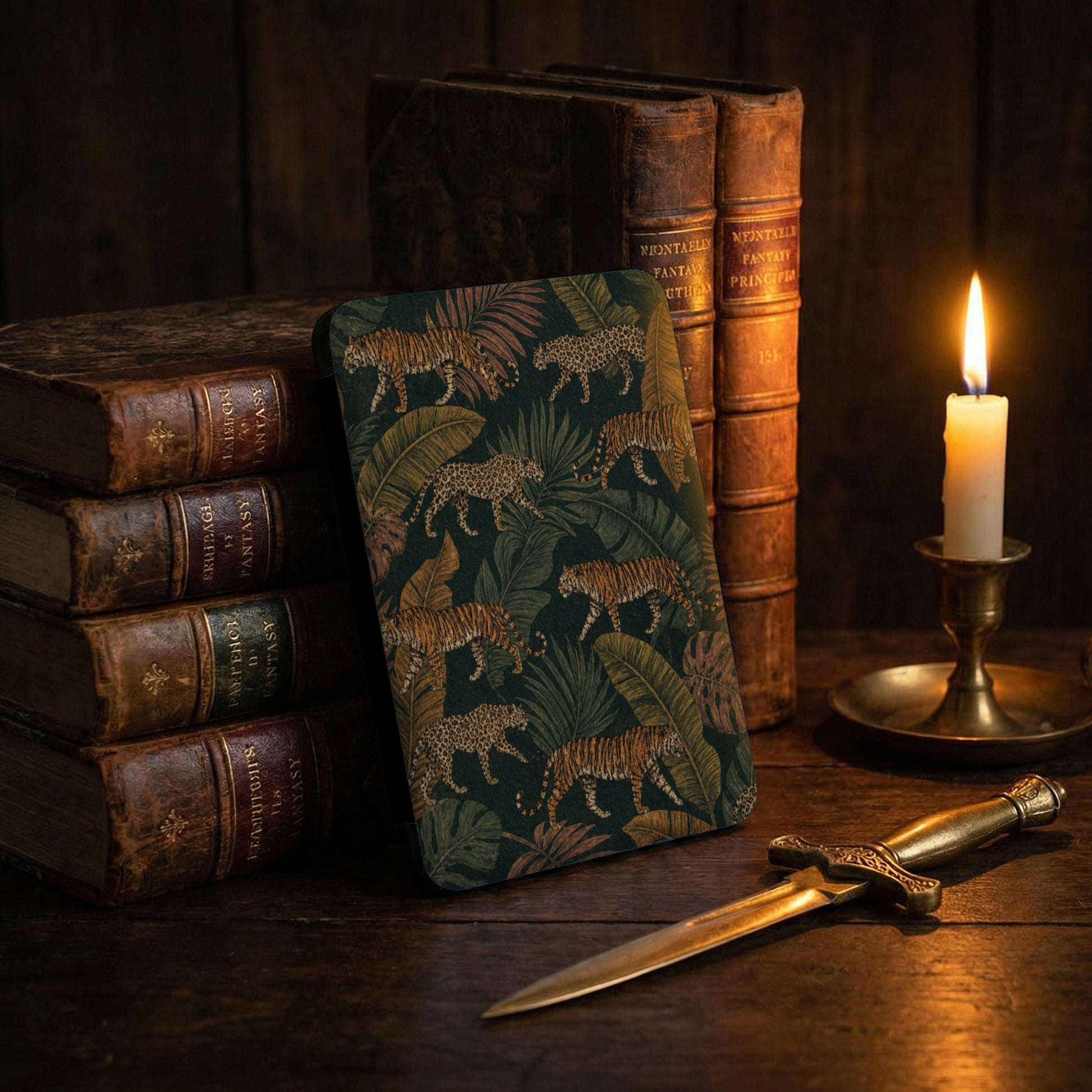 Case with tigers and leopards on a jungle background beside antique books and a candle.