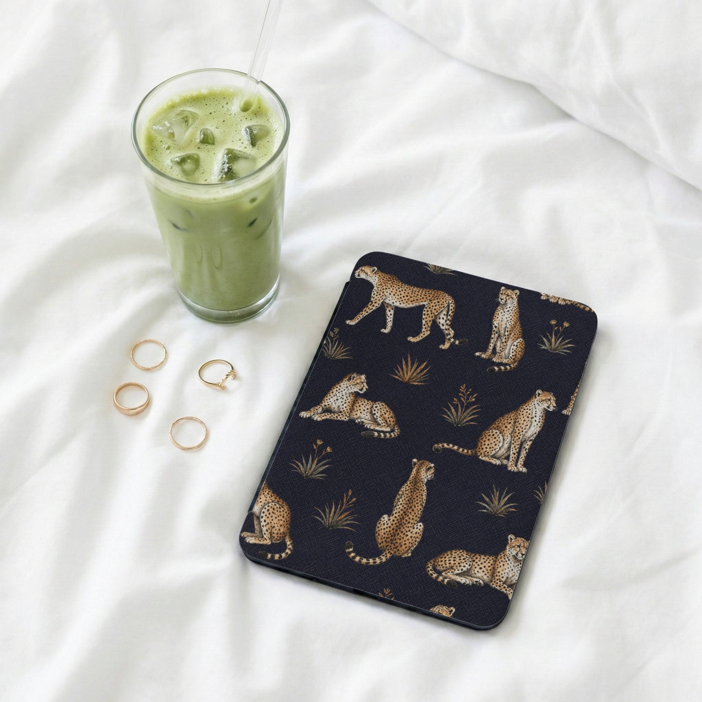 Dark case with a cheetah print pattern and several gold rings.