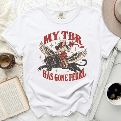 White t-shirt with graphic of winged panther, cowgirl, and text "MY TBR HAS GONE FERAL".