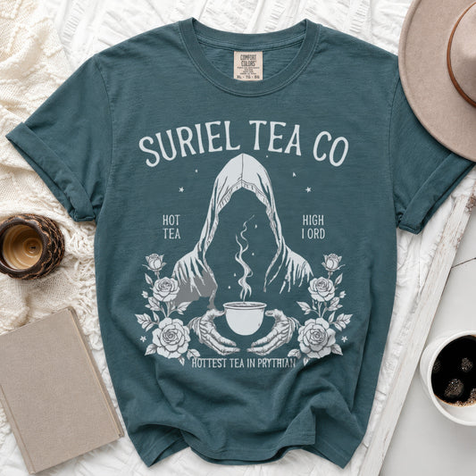 Teal t-shirt with "Suriel Tea Co" graphic featuring a cloaked figure, a cup of tea, and roses.