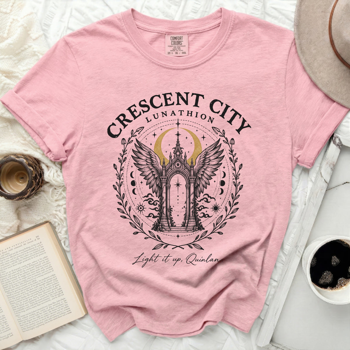 Pink t-shirt featuring a Crescent City graphic with an ornate winged archway and text.