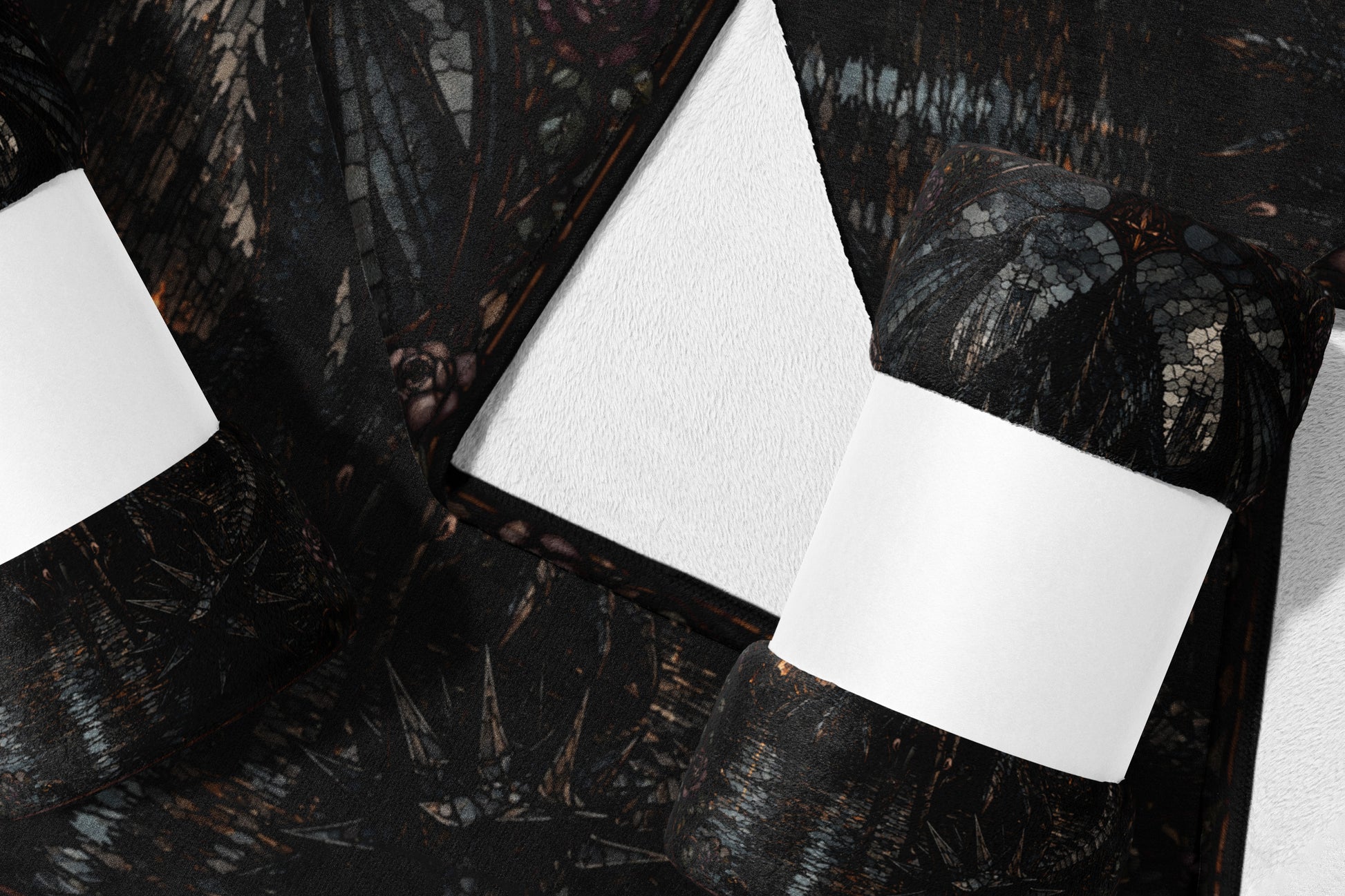 Dark patterned blanket with white paper band, folded on white surface.