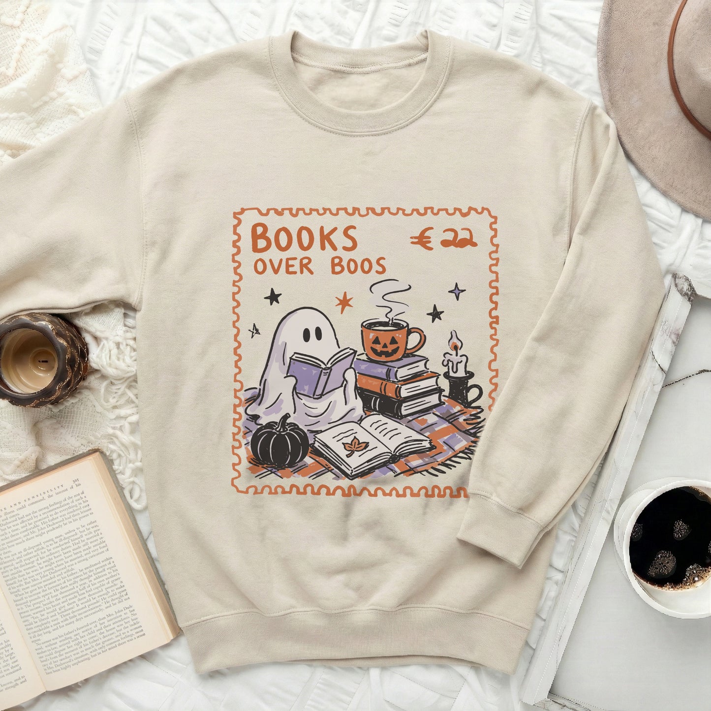 Cream sweatshirt with "Books Over Boos" ghost and pumpkin illustration.