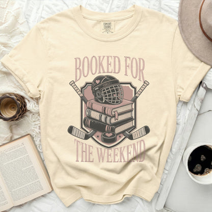 Cream t-shirt with "Booked For The Weekend" text and hockey gear design.