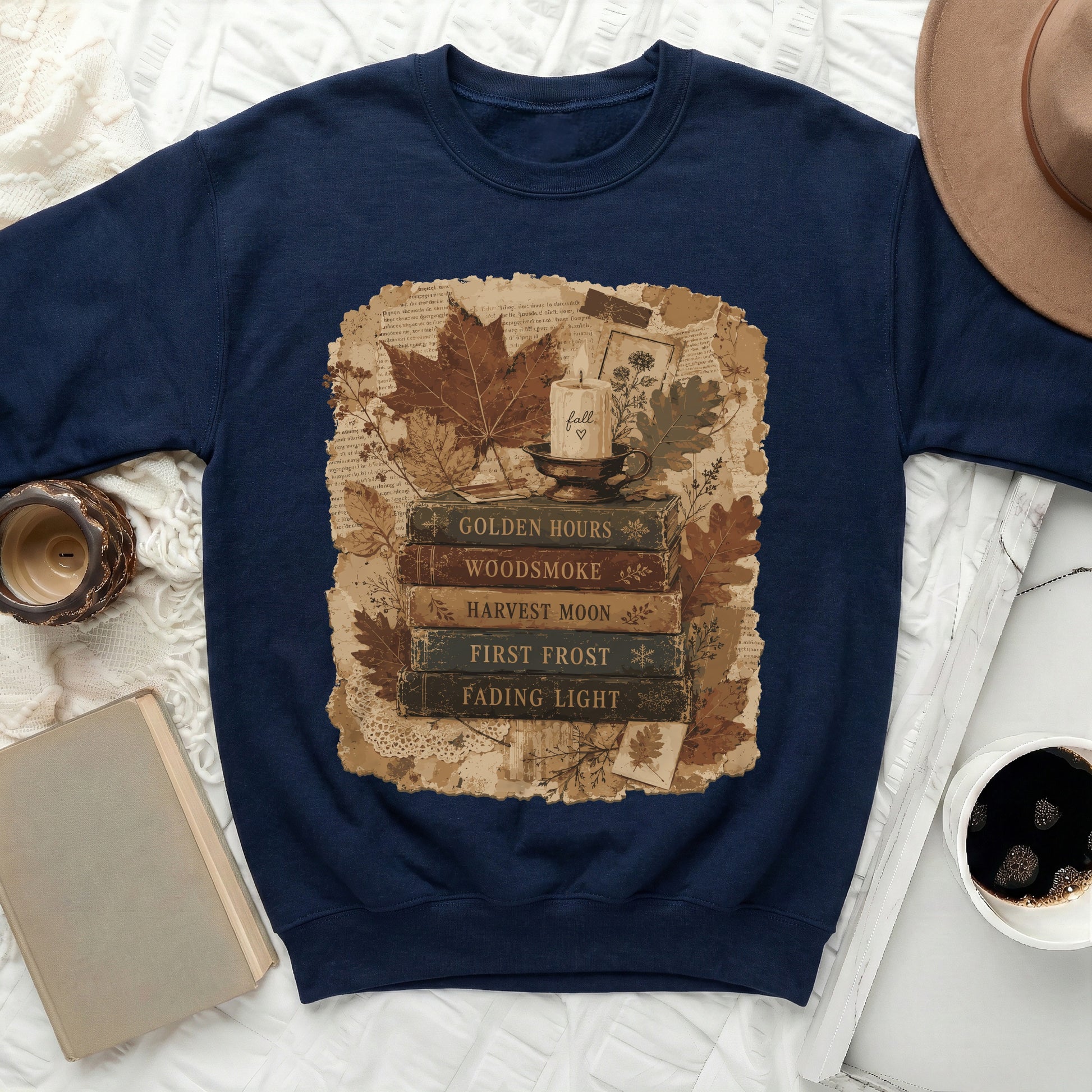 Dark blue sweatshirt with fall-themed graphic of books and a candle.