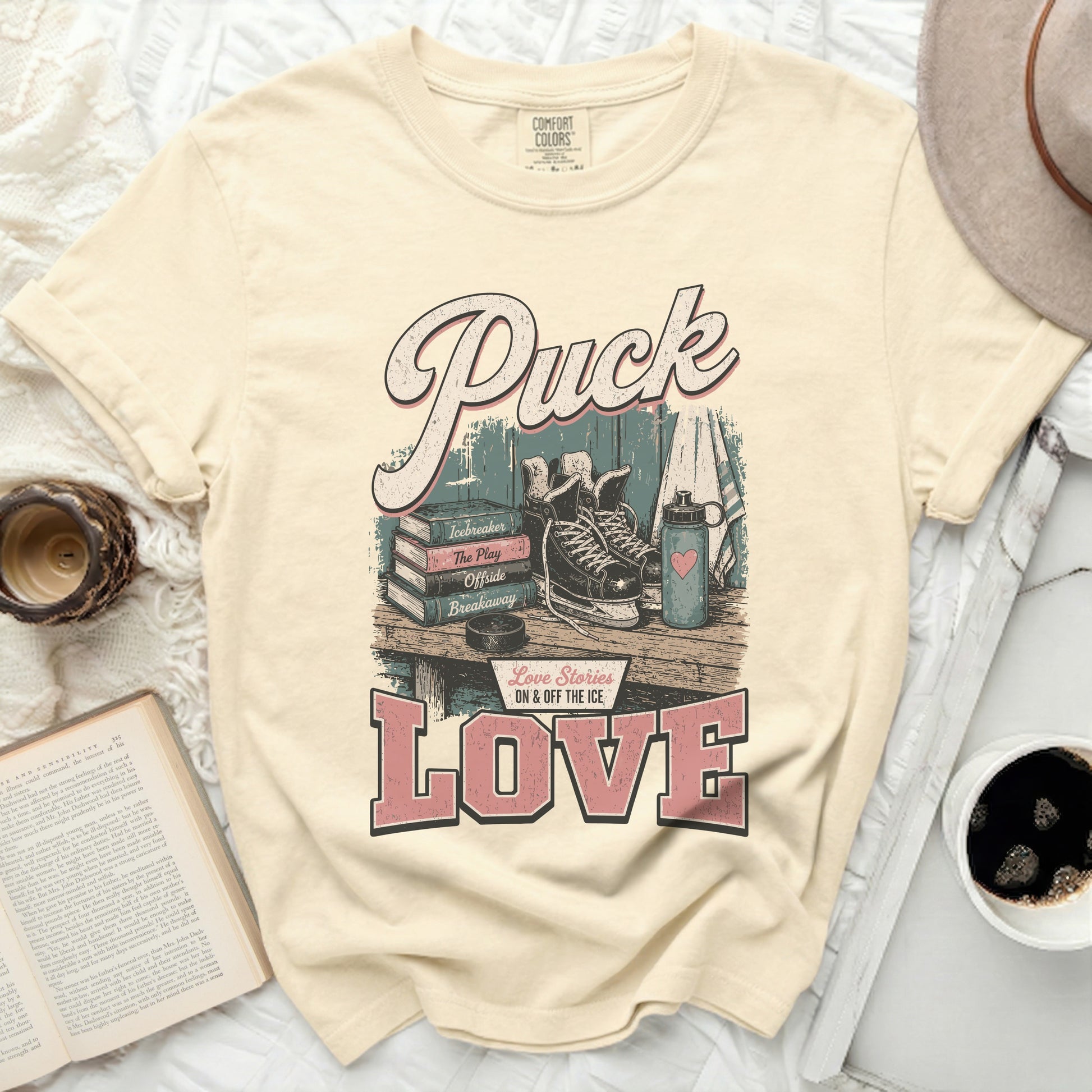 Cream t-shirt with "Puck Love Stories ON & OFF THE ICE LOVE" text.