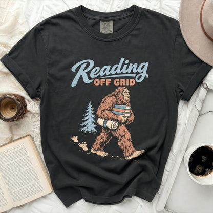 T-shirt graphic with Bigfoot carrying books, reading off grid text, and a tree.