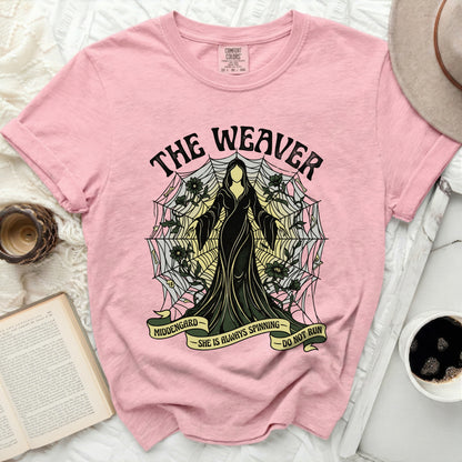 Pink t-shirt with "The Weaver" graphic and text "Middengard She Is Always Spinning Do Not Run".
