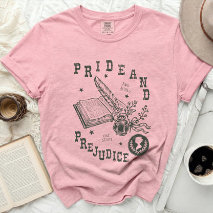 Pink t-shirt with a vintage-style graphic of an open book, quill, inkwell, and the words Pride and Prejudice.